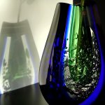 Moderne glaskunst, traditioneel geblazen glassculptuur of vaas met prachtige lichtreflecties op de wand 