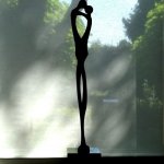 Het bronzen beeld 'Saamhorigheid, liefde' met tuin als achtergrond