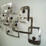 Het metalen kunstwerk voor de muur kan op meerdere wijzen worden opgehangen, doordat het 2-delig is 