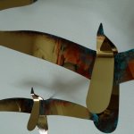 Een van de metalen vogels van wandobject Promenade met terra kleuren en groene bronstinten ...